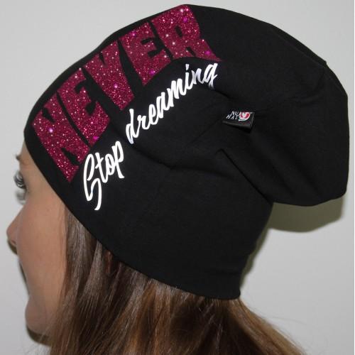 Musta trikoopipo isolla pinkillä glitter tekstillä nuoren naisen päässä