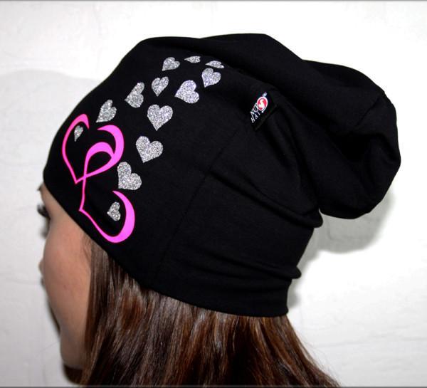 Musta trikoopipo pinkeillä ja glittersydämillä nuoren naisen päässä